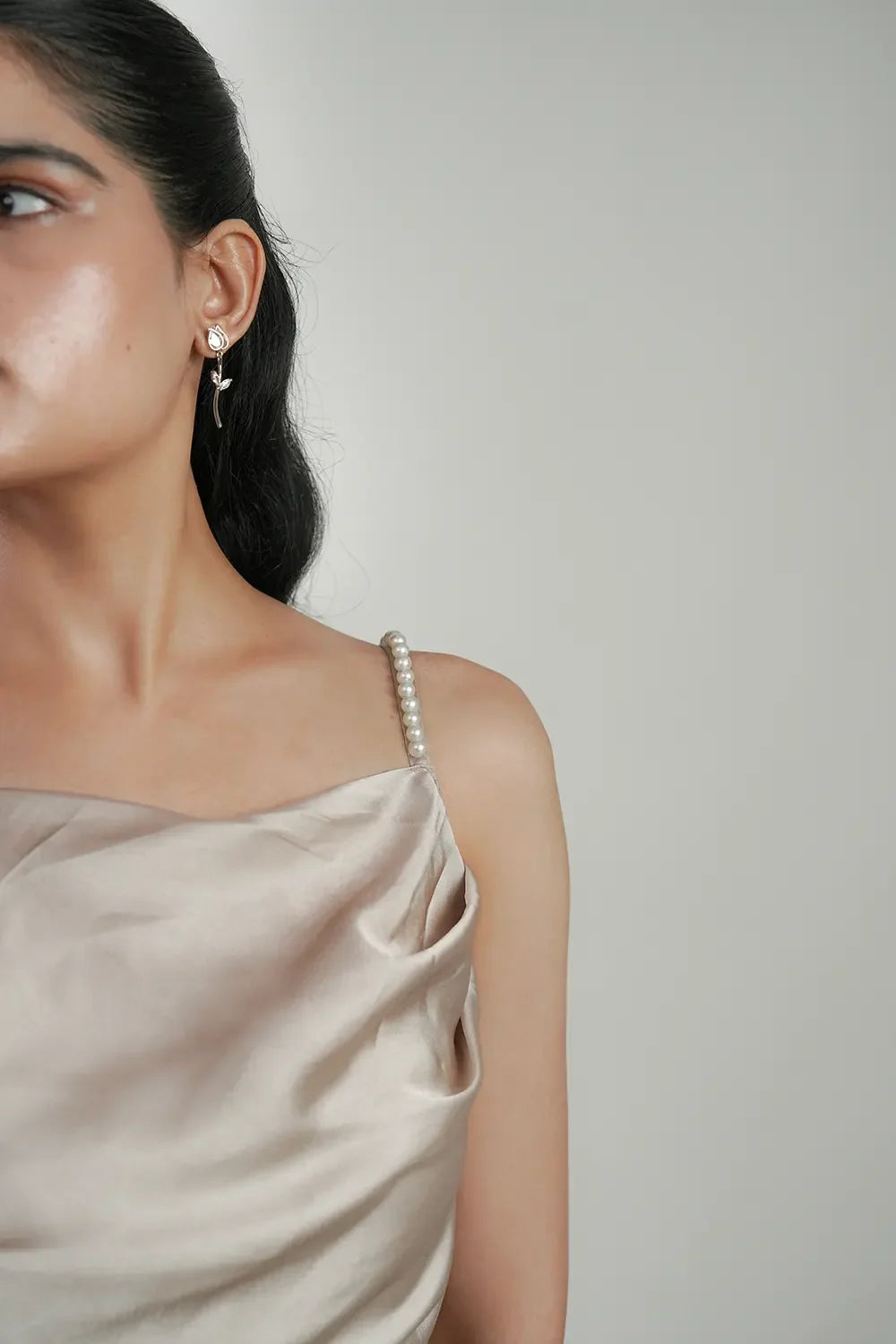 Woman in satin dress with pearl strap and floral earring, Streiq fashion photography