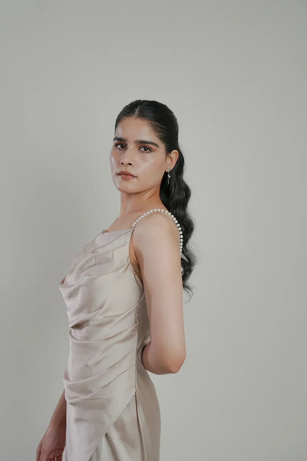 Woman in elegant silk dress with pearl strap, minimalist studio background, Streiq fashion