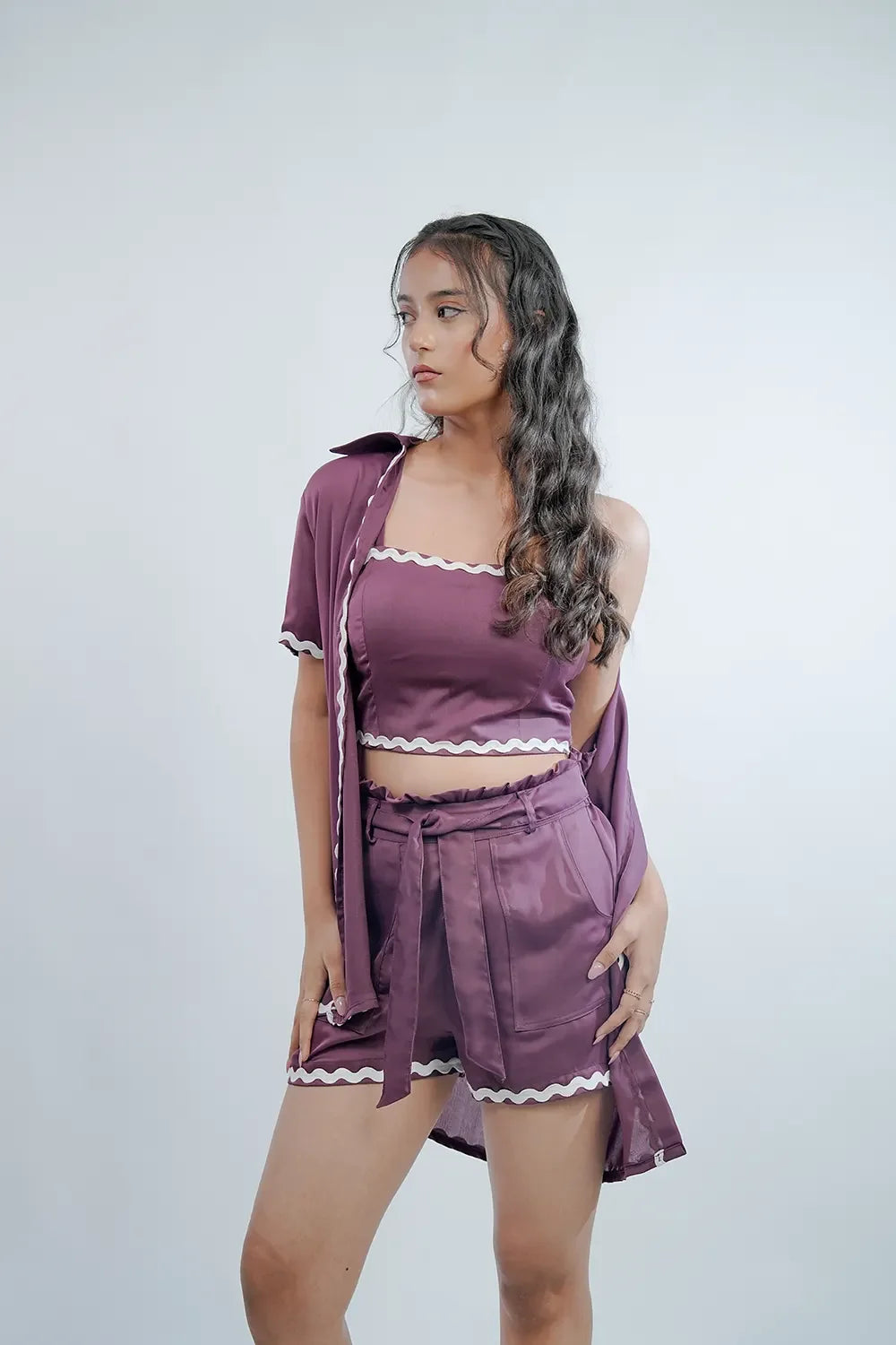 Woman wearing a stylish purple three-piece shorts set with white trim from Streiq
