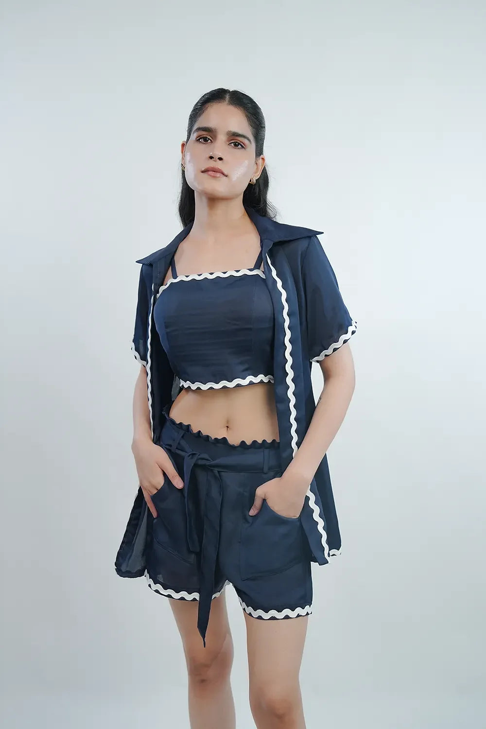 Woman wearing navy blue three-piece co-ord set with white trim from Streiq