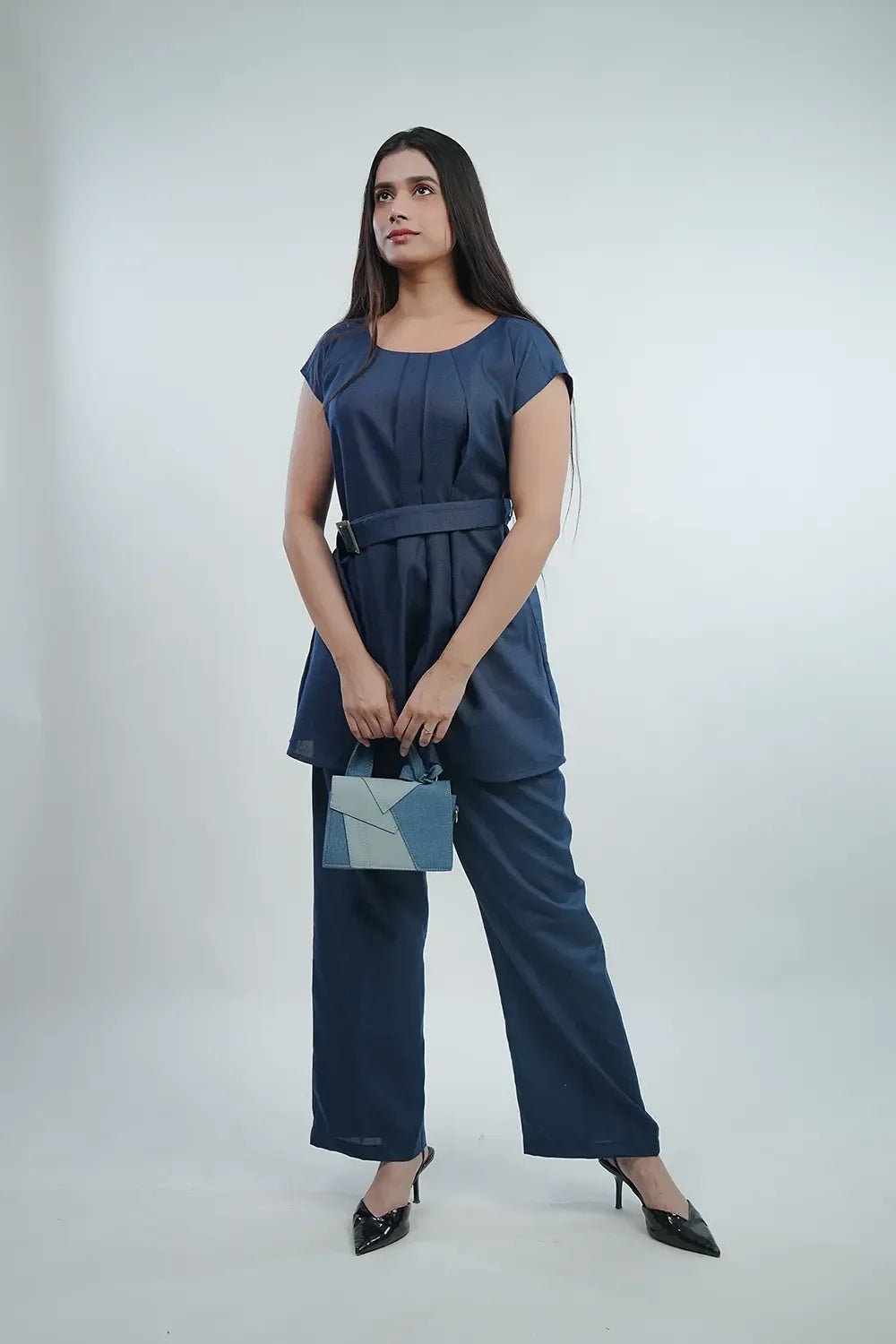 Woman in navy blue belted tunic and pants holding a geometric denim handbag, Streiq fashion