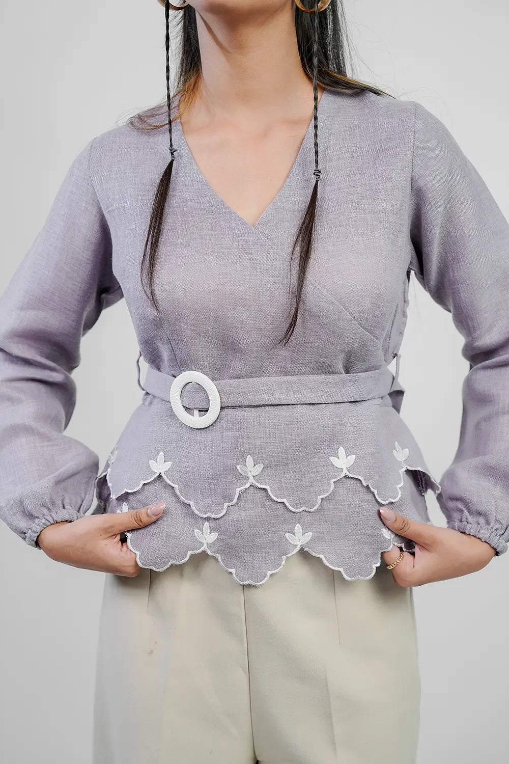 Woman in lavender blouse with scalloped embroidered hem and belt, Streiq fashion style