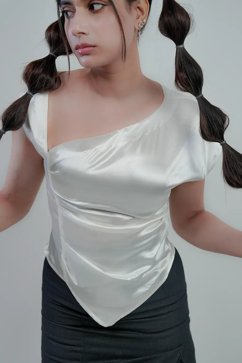 Woman in white asymmetrical satin top and black skirt, Streiq modern fashion style