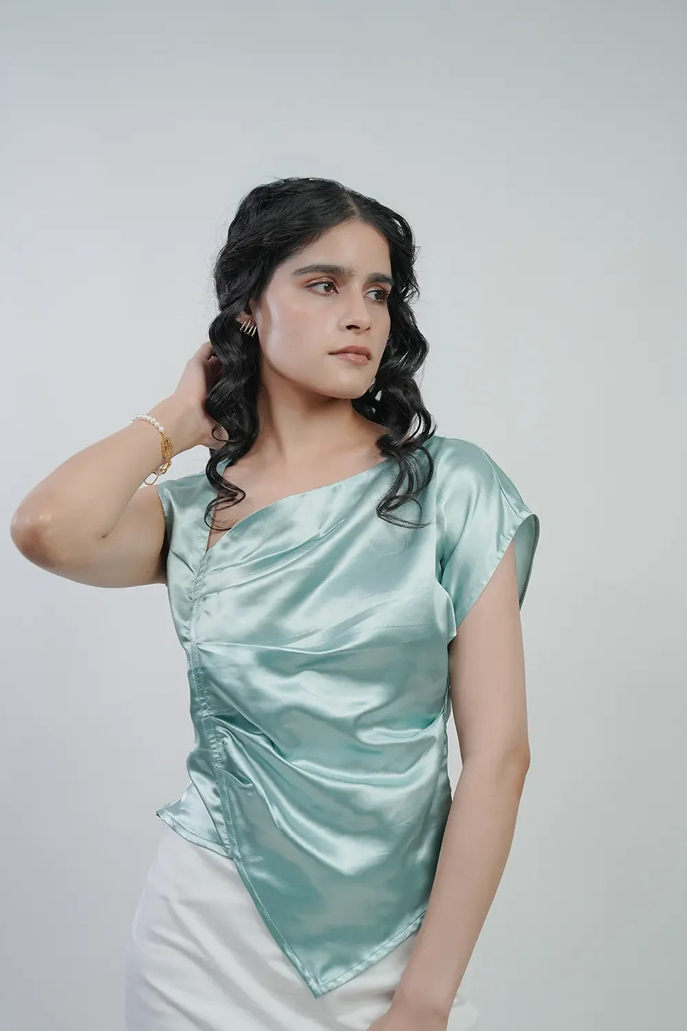 Woman modeling light blue satin top from Streiq, elegant fashion on neutral background