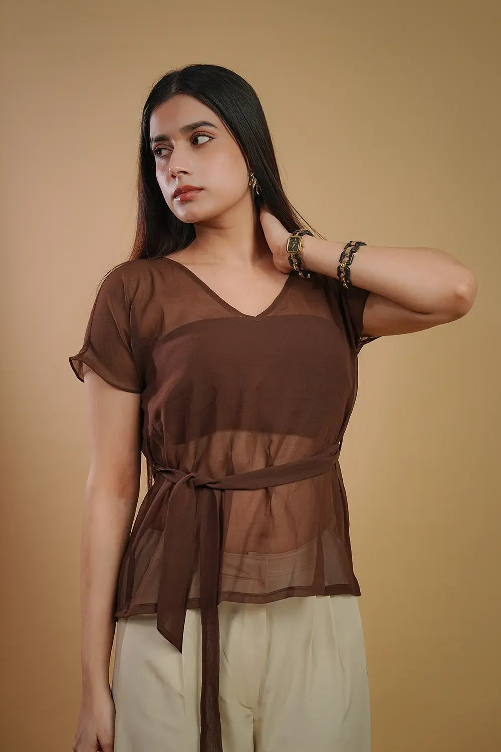 Woman wearing brown sheer top with waist tie and beige pants, Streiq fashion