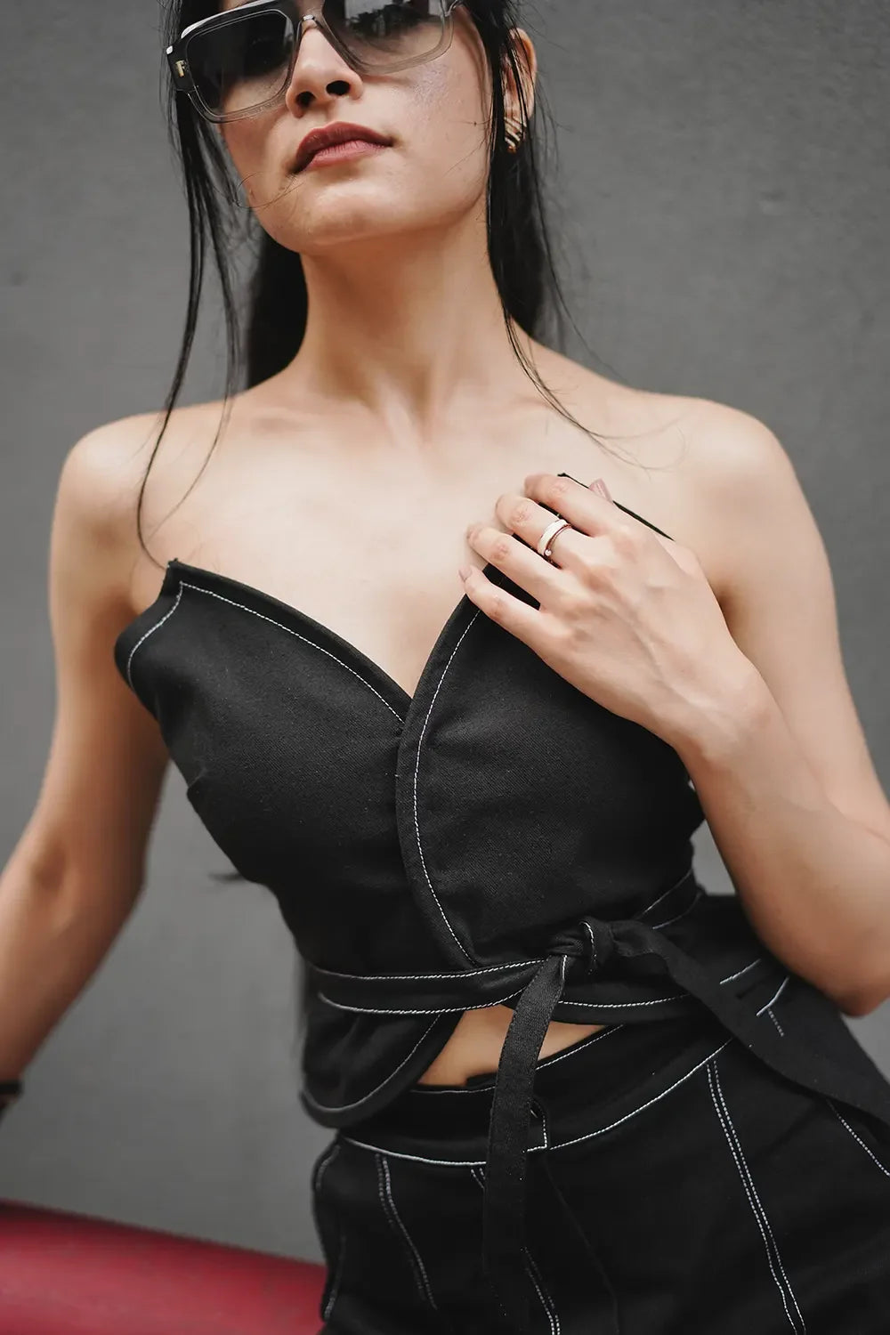 Woman in stylish black wrap top and pants with white stitching, Streiq fashion