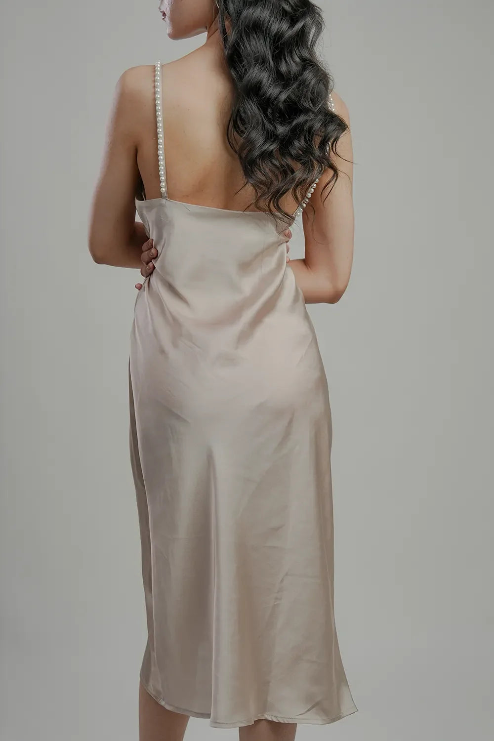 Back view of woman in pearl strap satin slip dress, Streiq fashion style