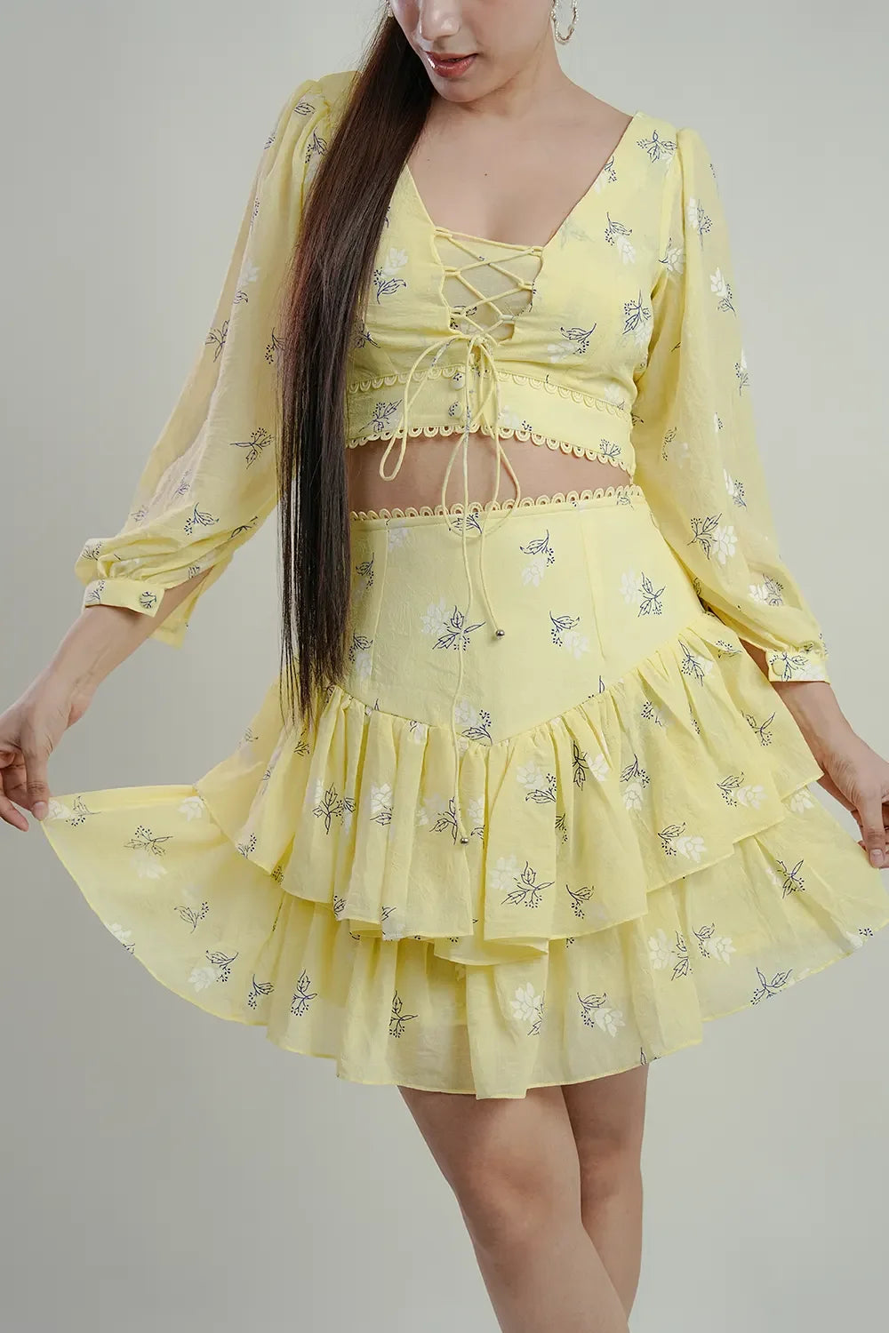 Woman wearing a yellow floral crop top and ruffled skirt set from Streiq