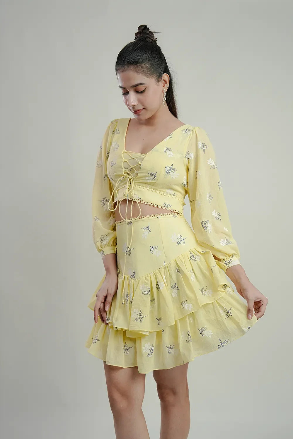 Woman in a yellow floral lace-up top and ruffled skirt, Streiq fashion clothing