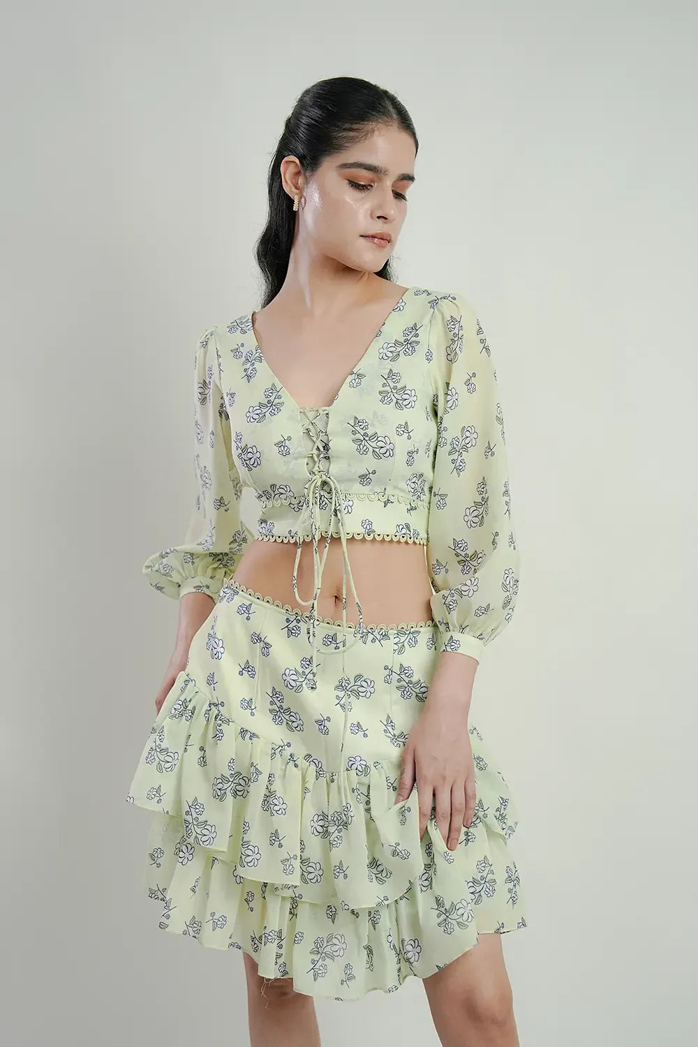 Woman in light green floral crop top and ruffled skirt, stylish Streiq fashion outfit