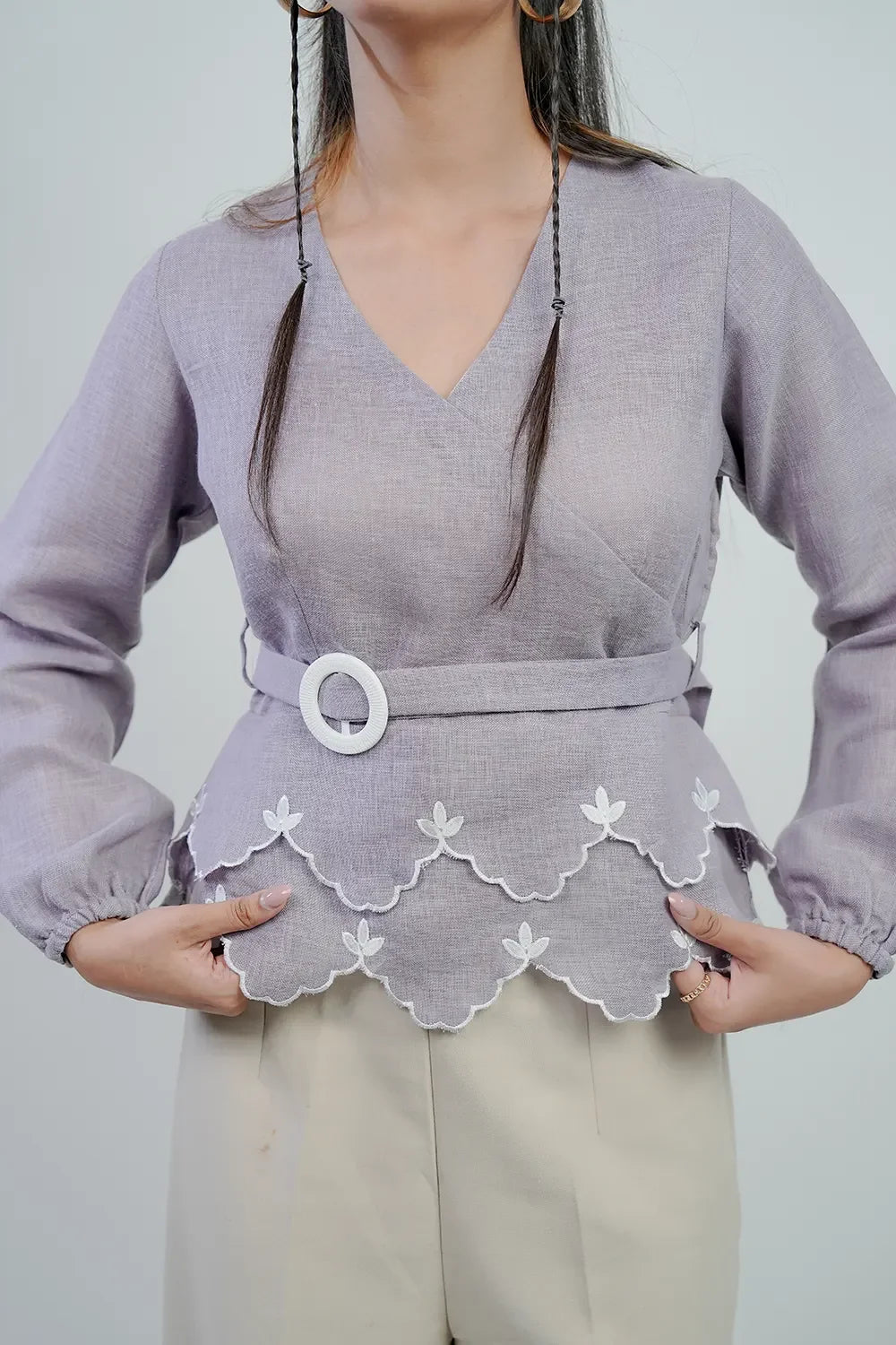 Woman wearing a lilac belted blouse with scalloped hem and white embroidery, Streiq fashion
