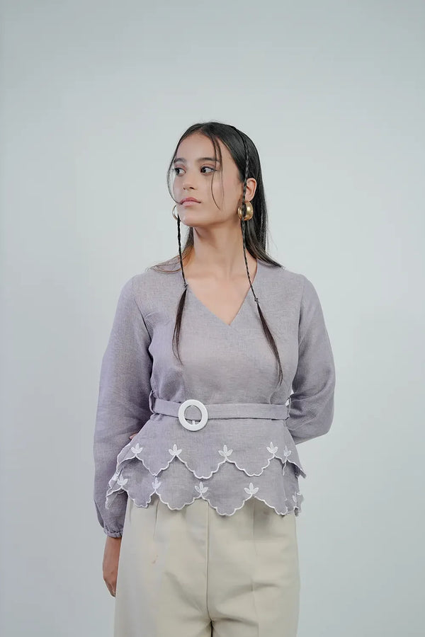 Woman in lilac belted peplum blouse with scalloped hem, neutral background, Streiq fashion
